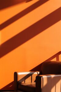 Mid-century armchair against a warm orange wall